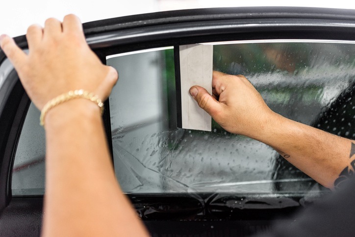 Person applying window tint film on the car side window in Portland, OR